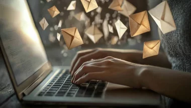 henkilö kirjoittaa tietokoneella, leijailevia kirjekuoria