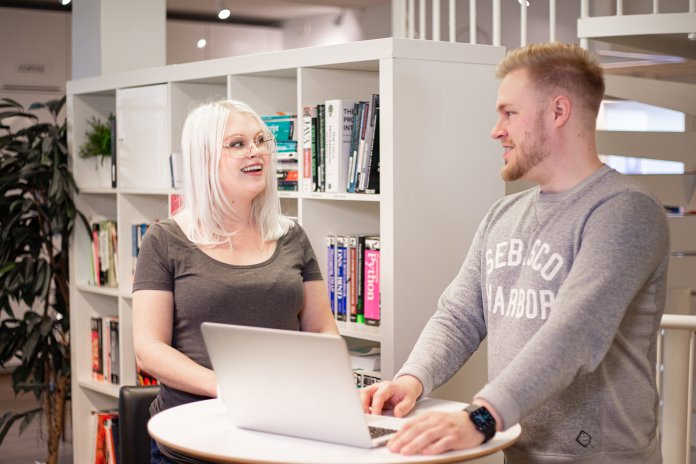 Kaksi henkilöä keskustelee kansainvälisestä mediaseurannasta