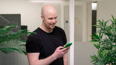 Mies katsoo puhelinta