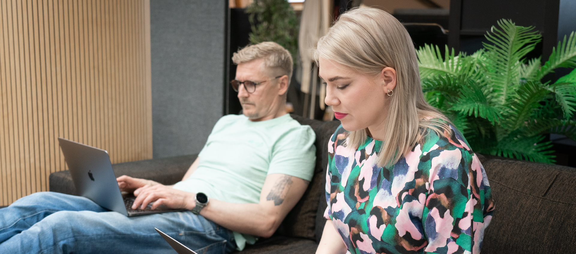 Kaksi henkilöä istuu sohvalla tekemässä some-seurantaa